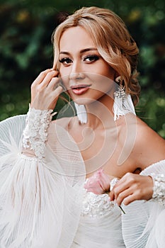 Wedding earrings on a female hand, she takes the earrings, the bride fees, morning bride, white dress, wear earrings