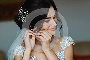 Wedding earrings on a female hand wear, she takes the earrings, the bride fees, morning bride, woman in white dress