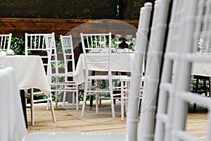 Wedding event. Chiavari chairs on the covered wooden deck.