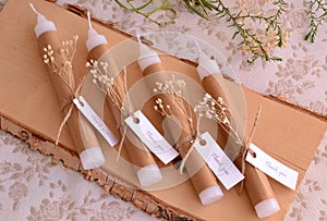 Wedding favors white candles decoration with brown beige craft paper jute ribbon and dry flowers