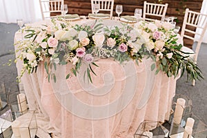 Wedding floral table decoration with candles in transparent vases