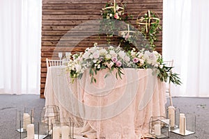 Wedding floral table decoration, near candles in transparent vases