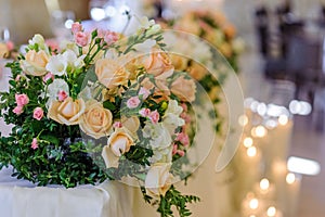 Wedding flower arrangement on the background of burning candles