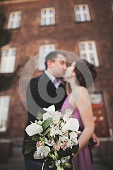 Wedding flowers bouquet with newlywed couple on background