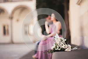 Wedding flowers bouquet with newlywed couple on background