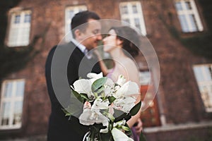 Wedding flowers bouquet with newlywed couple on background