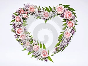 Wedding frame of flowers in heart-shaped: rose, lilac, rowan leaves on a white background. Floral pattern. Copy space for text