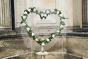 Wedding fresh wreath of white roses with green leaves