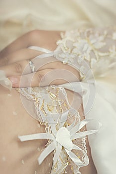 Wedding garter put on beautiful bride leg