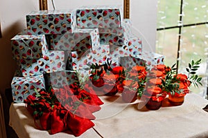 Wedding gifts for guests: boxes with cakes, sweet jars with jam and pouches with candies. Presents and bonbonnieres in red colors