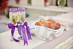 Wedding glasses with sparkling wine and purple ribbons