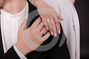 Wedding gold rings on the hands of the newlyweds. Gold rings on the hand of a man and a woman