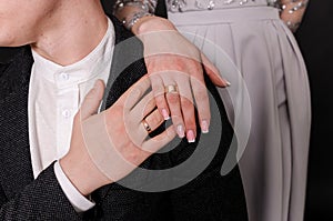 Wedding gold rings on the hands of the newlyweds. Gold rings on the hand of a man and a woman