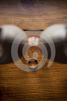 Wedding golden ring in focus lie on the wooden background another wedding ring between the bride`s shoes.