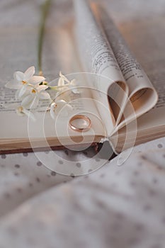 Wedding golden ring and open book with folded sheets in heart shape. Wedding concept, Valentines Day