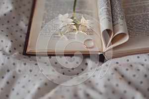 Wedding golden ring and open book with folded sheets in heart shape. Wedding concept, Valentines Day