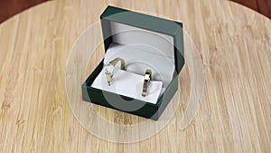 Wedding golden rings with diamond on wooden background in jewellery box. footage to jewelry for marriage with copy space