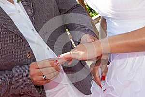 Wedding groom wears bride ring exchange