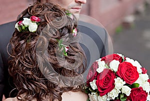 Wedding hairstyle with roses and bridal bouquet back view