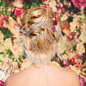 Wedding hairstyle a young girl. Bride. Woman with Flowers in her