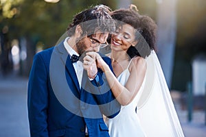 Wedding, happy couple and kiss on hand at marriage celebration event together with commitment. Interracial man and woman