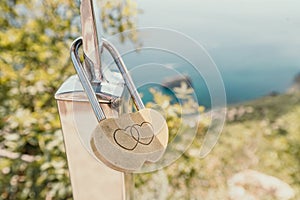 Wedding Heart Golden Lock on stainless iron fence. Valentine& x27;s day. Symbol of eternal love. A wedding tradition all