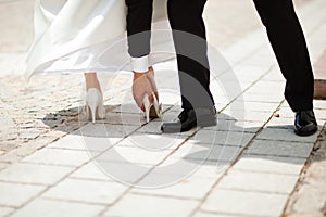 Wedding heel stuck in small gap on paving -Groom is helping - Awkward moment before ceremon