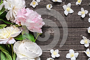 Wedding invitation or anniversary greeting card mockup decorated with pink and creamy peonies and jasmine flowers