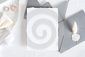 Wedding invitation card mockup, grey envelopes, rings on white background. Flat lay, top view. Minimal style