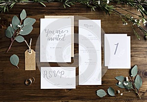 Wedding Invitation Cards Papers Laying on Table Decorate With Le