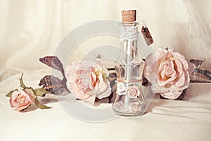 Wedding invitation in a glass bottle and pink roses