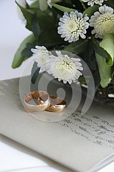 Wedding invitation, golden rings and flowers