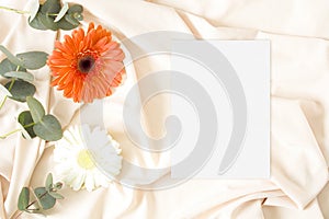 Wedding invitation mockup with gerbera and nude fabric