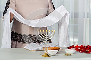 Before the wedding, a Jewish woman holds a white handkerchief in her hands, reciting prayers for family life telilim.