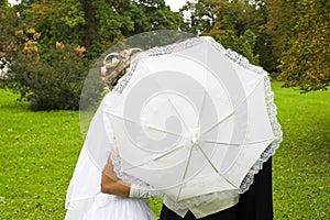 Wedding kiss behind umbrella