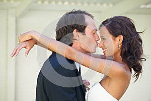 Wedding, kiss and bride and groom hug outdoor with love, romance and commitment together. Marriage, reception and couple