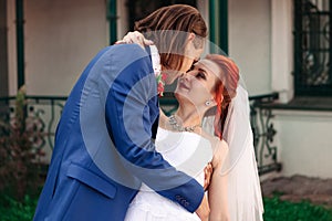 Wedding kiss. Groom and bride are kissing in the park.