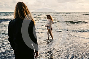 Wedding lovestory, just married couple near the ocean at sunset