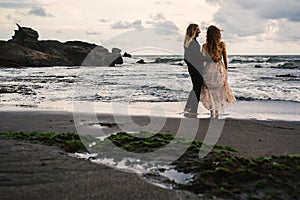 Wedding lovestory, just married couple near the ocean at sunset