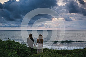 Wedding lovestory, just married couple near the ocean at sunset