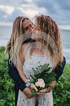 Wedding lovestory, just married couple near the ocean at sunset