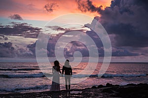 Wedding lovestory, just married couple near the ocean at sunset