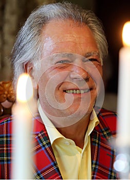 While the wedding the lucky bridegroom in scottish tartensuit behind the candles photo