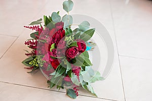 Wedding. Lush bridal Bouquet of red roses and a lot of greenery