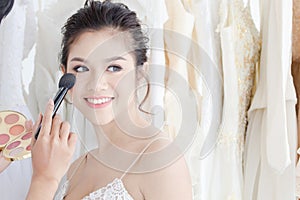 Wedding make up artist use the skill provide the a beautiful Asian bride in wedding dress room or studio, Beautiful  young bride