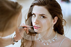 Wedding makeup artist making a make up for bride