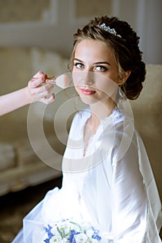 Wedding makeup artist making a make up for bride