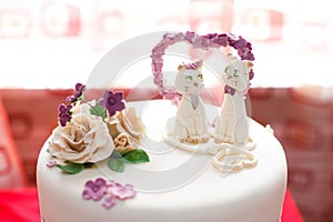 Wedding mastic cake decorated with flowers and cat figures, closeup