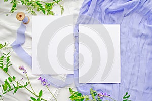 Wedding mockup with violet flowers and delicate silk ribbons on a white background. Greeting card or wedding invitation with
