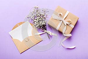 Wedding mockup with white paper list and flowers gypsophila on colored table top view flat lay. Blank greeting cards and